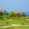 Paesaggio con giardino, case e vista mare.