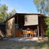 Bungalow rustico con sedie e sdraio all'aperto.