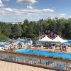 Panoramica di piscine affollate con tende e scivoli.