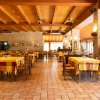 Ampio ristorante con tavoli apparecchiati e sedie.