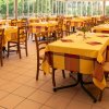 Sala da pranzo luminosa con tavoli apparecchiati.