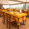 Sala ristorante con tavoli gialli apparecchiati.