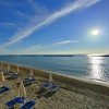 Spiaggia sabbiosa al tramonto con ombrelloni.