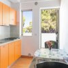 Cucina arancione con tavolo vicino alla finestra.