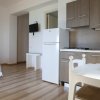 Una cucina moderna con frigo bianco e tavolo bianco.