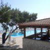 Piscina con lettini e ombrelloni vicino a un ristorante.