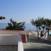 Vista mare con terrazza e piscina tra alberi.