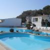 Piscina azzurra circondata da lettini e ombrelloni.