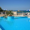 Piscina con lettini e vista sul mare.