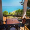 Tavolo su balcone con vista mare e pini.
