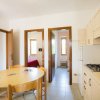 Cucina con tavolo rotondo e porte rosse.