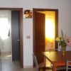 Interno con tavolo, fiori e due porte aperte su stanze luminose.