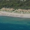 Edifici fronte mare e spiaggia con ombrelloni colorati.