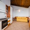 Cucina con divano giallo sotto soffitto in legno.
