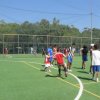 Ragazzi giocano a calcio su un campo all'aperto.