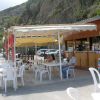 Un piccolo caffè all'aperto con tavoli e sedie sotto un tendone.