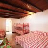 Camera con letto matrimoniale, letti a castello e arredi a righe rosse. Tavolino e sedie.