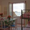 Interno con tavolo e letti a castello, vista mare dalla finestra aperta.