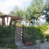 Cancello e giardino verdeggiante vicino a una casa bianca.