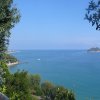 Vista panoramica del mare azzurro con un'isoletta all'orizzonte.