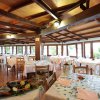 Ristorante con tavoli apparecchiati e piatti decorati, grandi finestre luminose.