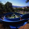 Uno scivolo d'acqua blu in un parco con vista su colline e mare.