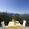 Tavolo con tovaglia gialla, panorama di mare e montagne.