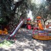 Un parco giochi con scivoli, altalene e giostra.