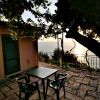 Due sedie e un tavolo in terrazza con vista mare al tramonto.
