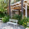 Panchine bianche vicino a una veranda con giardino.