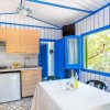 Cucina in bungalow con finestre blu e tavolo apparecchiato.