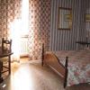 Una camera con letto matrimoniale, tende a fiori e pareti a righe.