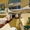 Terrazza di un hotel con ombrelloni e sedie bianche.
