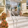 Ingresso di un hotel con gradini e fiori rossi.