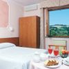 Una camera da letto con letto matrimoniale, tavolino con colazione e vista su colline.