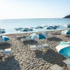 Ombrelloni bianchi e blu su una spiaggia sabbiosa.