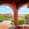 Archi di una terrazza con vista su edifici e giardino.