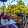Balcone con tavolo, fiori e vista alberi.