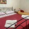 Camera con letto matrimoniale e singolo, pareti bianche.