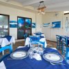 Ristorante con sedie blu e tavoli apparecchiati.