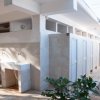 Esterno di bagni pubblici con lavandini bianchi.