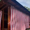 Bungalow in legno con tende a strisce rosse e bianche.