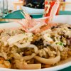 Risotto ai frutti di mare con gamberi e calamari, servito su un piatto bianco.