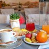 Colazione con caffè, succhi, frutta e dolci su un tavolo apparecchiato.