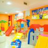 Sala giochi per bambini con scivoli colorati e giocattoli.