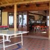 Una veranda con tavolo da ping pong e vista su un bar interno.