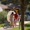 Famiglia cammina su un vialetto con attrezzature da spiaggia.