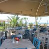 Sala da pranzo all'aperto con sedie bianche e blu, vista mare.