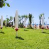 Ombrelloni chiusi su un prato verde vicino al mare.