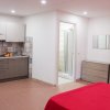 Interno di un monolocale con angolo cottura e bagno, arredato con mobili moderni.